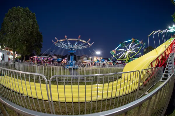 Midway swings and rides lit up at night at the fair