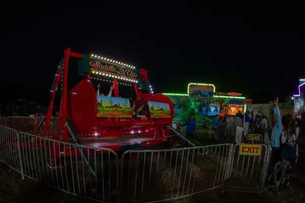 Saddle Up ride and glowing game booths after dark
