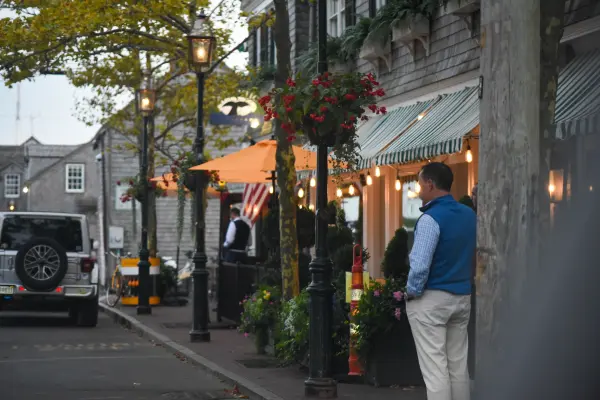 Passerby outside the Atlantic restaurant at dusk