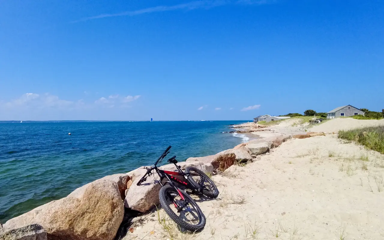 Bicycle leaning on rocks at the edge of the water on a sunny day