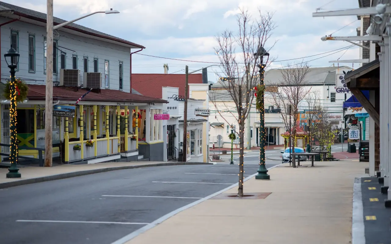 An almost empty Circuit Avenue in Oak Bluffs in December, holiday lights wrapped around lamp posts and bare trees