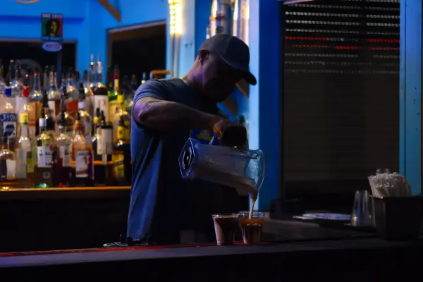 Bartender pouring a frozen dirty banana cocktail from the blender