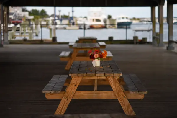 Flowers on picnic tables under a pavilion by Edgartown Harbor