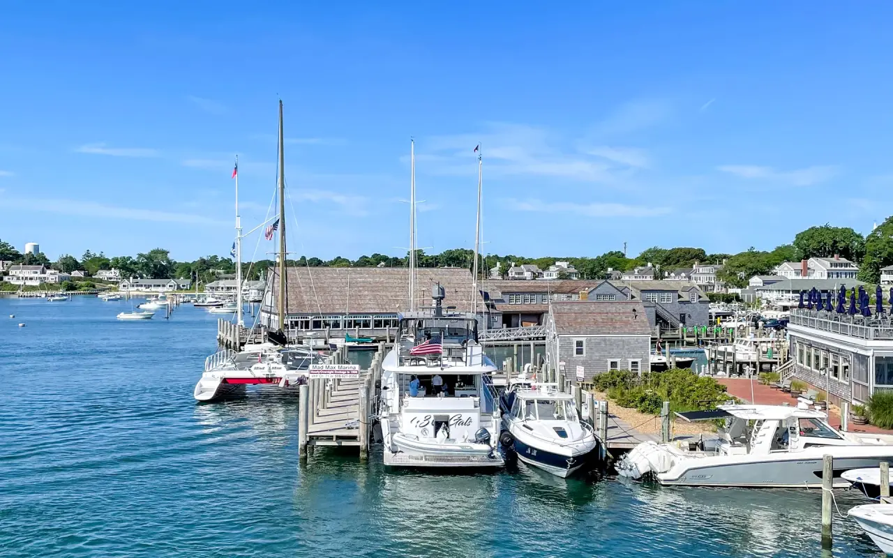 Edgartown Harbor with motorboats at the docks and shingled buildings along the waterfront on a sunny day
