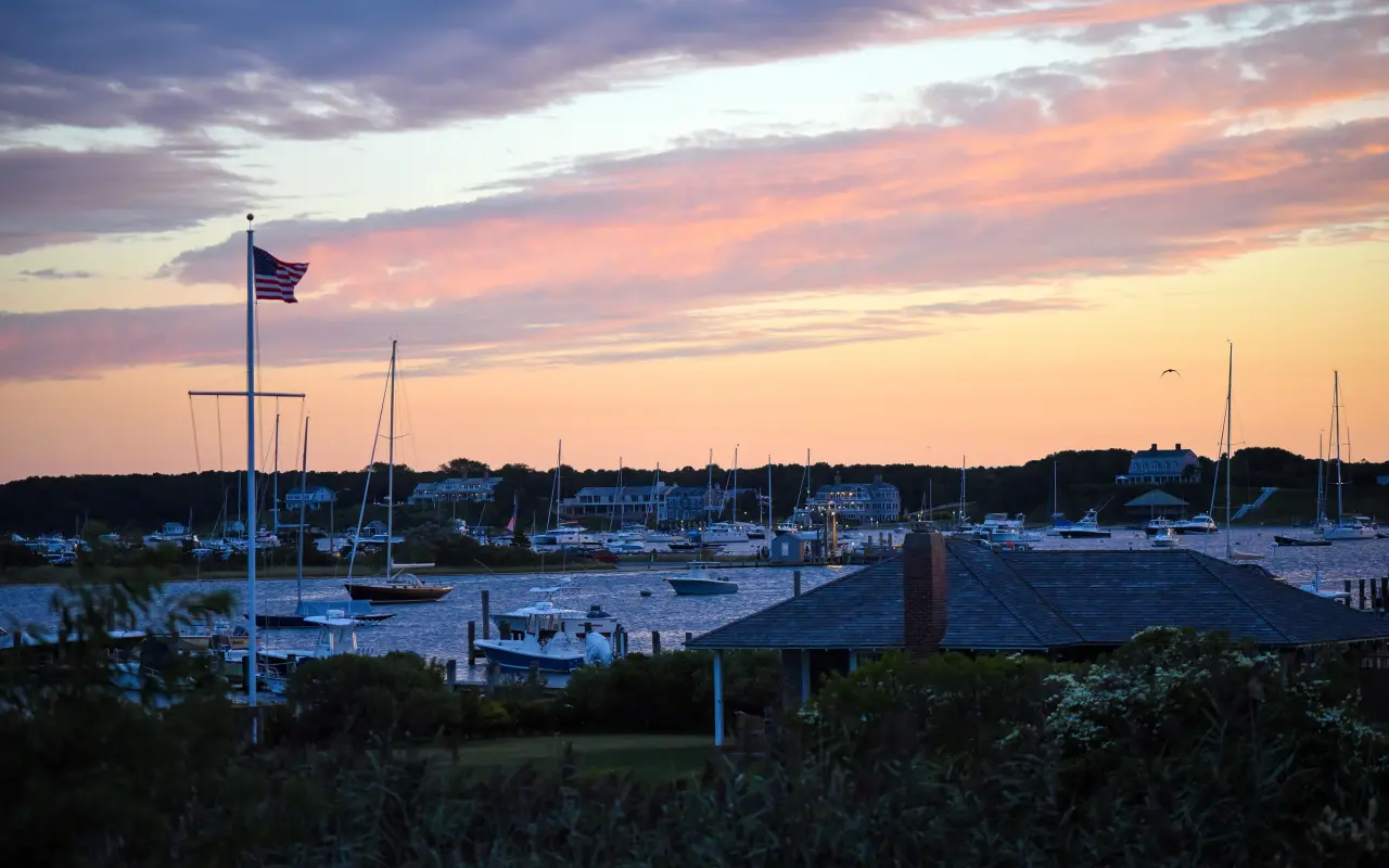 Edgartown Harbor with boats and a flagpole under a pink dusk sky