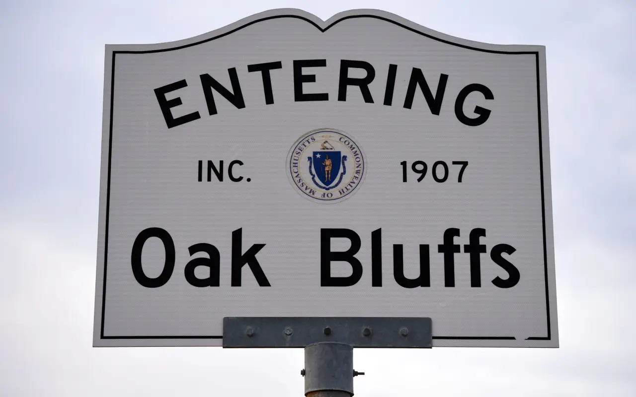 White Entering Oak Bluffs town sign with the Massachusetts seal against a pale sky