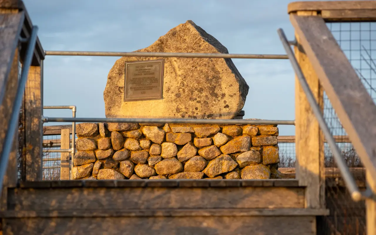 Bronze plaque mounted on a boulder atop a stone wall at the Aquinnah Cliffs overlook
