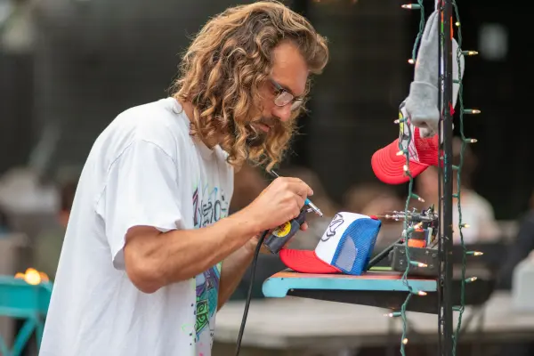 Island Spray artist airbrushing a custom trucker hat