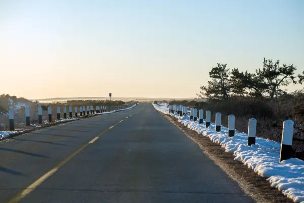 Snow-lined road with striped guard posts leading toward South Beach