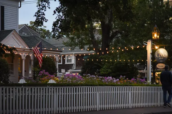 Picket fence and string lights at L'etoile at dusk