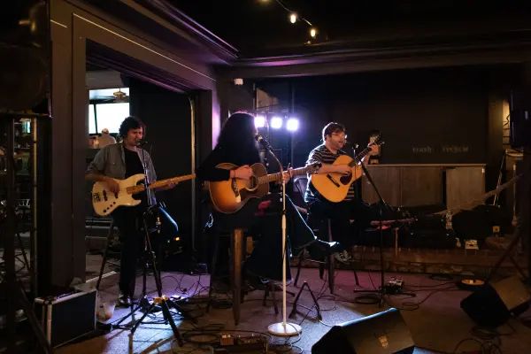 A full band on a small island stage in 2025.