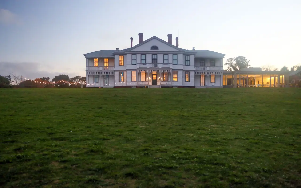 The Martha’s Vineyard Museum at dusk from the lawn, windows lit