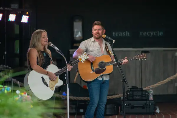 Martin and Kelly singing together at an outdoor show