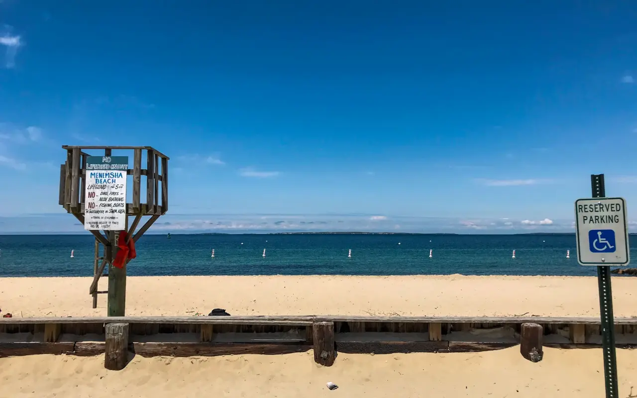 Lifeguard stand with a rules board at Menemsha Beach, swim buoys in the water behind