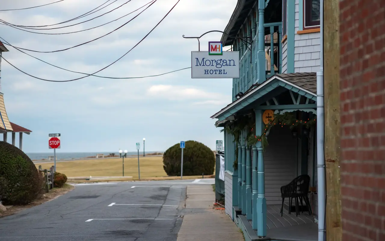 Covered porch of a small hotel on a quiet Oak Bluffs street with the water at the end of the road