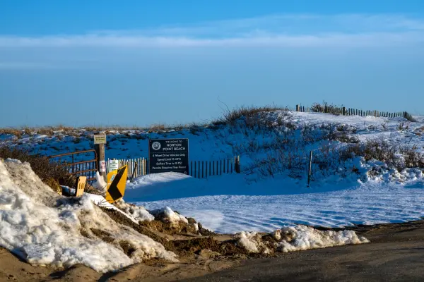 Snow-covered entrance and sign at Norton Point Beach