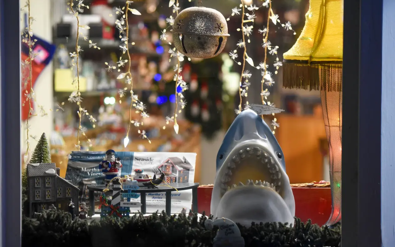 A shop window in Oak Bluffs decorated with holiday lights, ornaments and a model shark