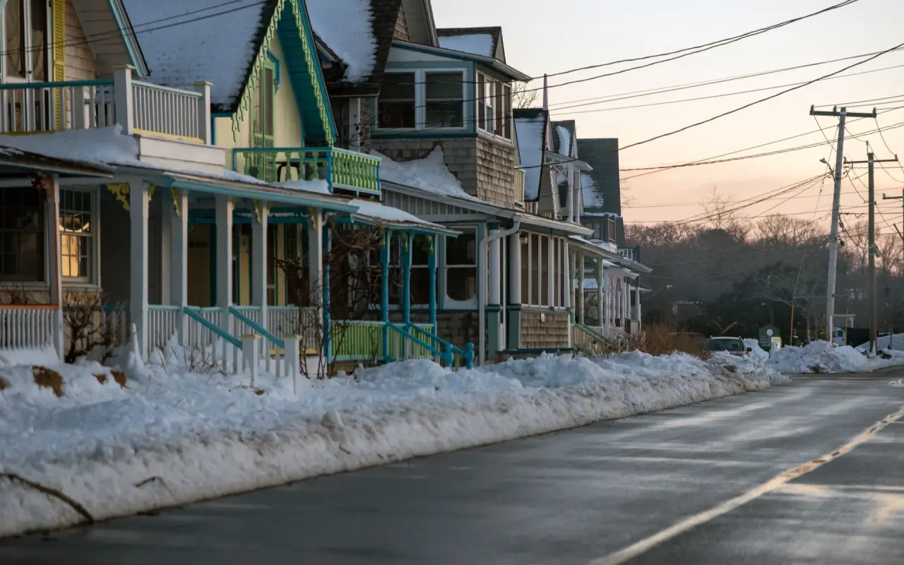Gingerbread cottages in Oak Bluffs with snow along the street at dusk