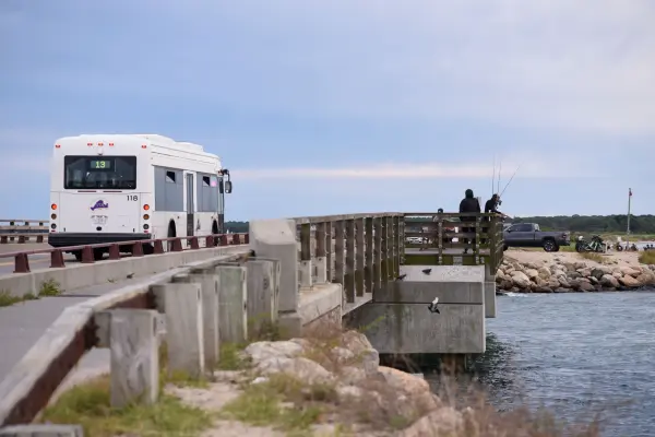 Route 13 bus crossing the bridge as anglers fish below