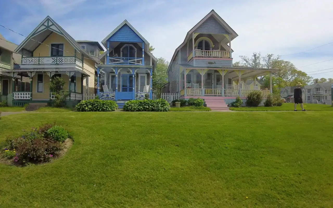 Colorful Victorian gingerbread cottages facing a green lawn in Oak Bluffs
