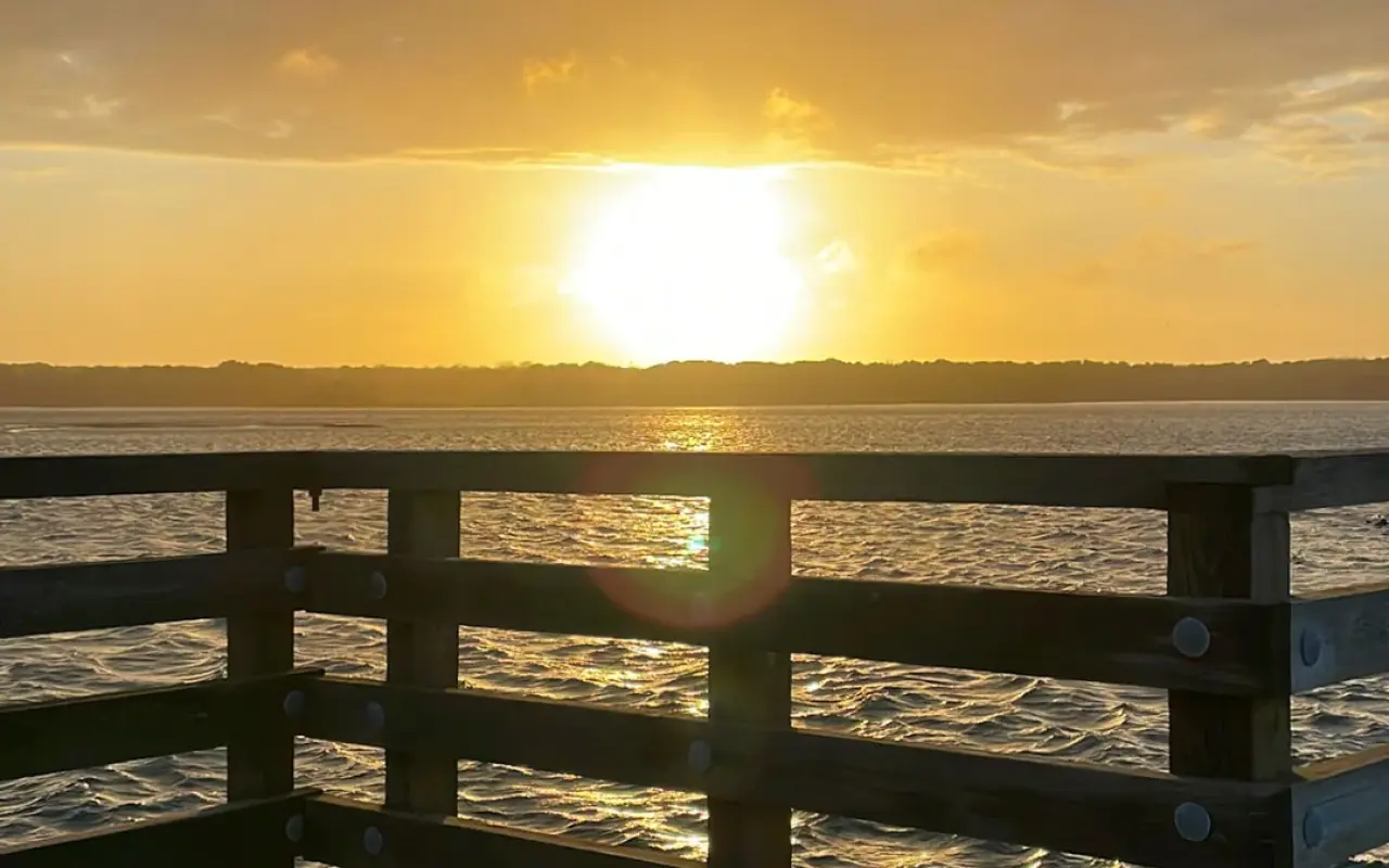 Sunset over the water seen from a railing on the Oak Bluffs waterfront