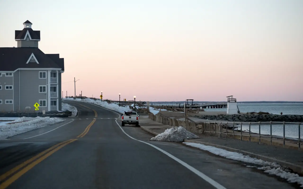 Seaview Avenue in Oak Bluffs in winter with snow along the sea wall and the pier beyond