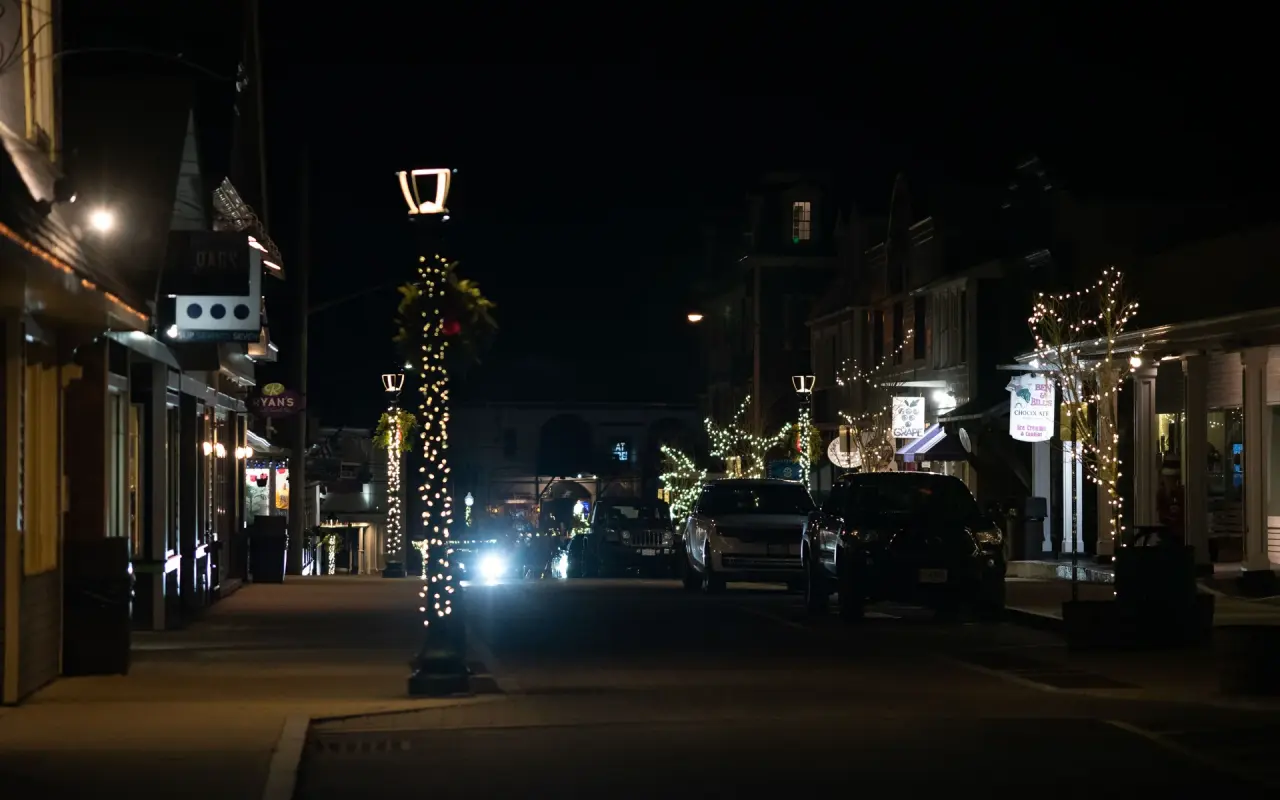 Circuit Avenue in Oak Bluffs at night with string lights and a few parked cars