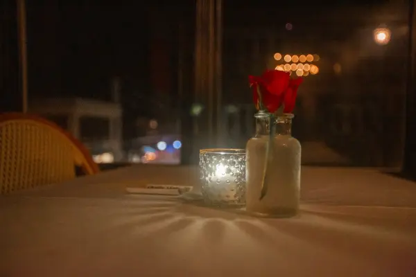 Candlelit window table, a rose in the bottle