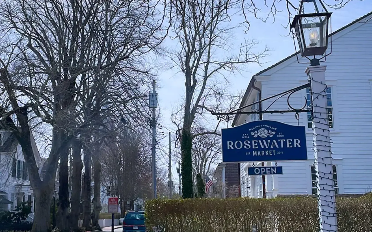 The Rosewater Market sign on a white building on a tree-lined Main Street in Edgartown