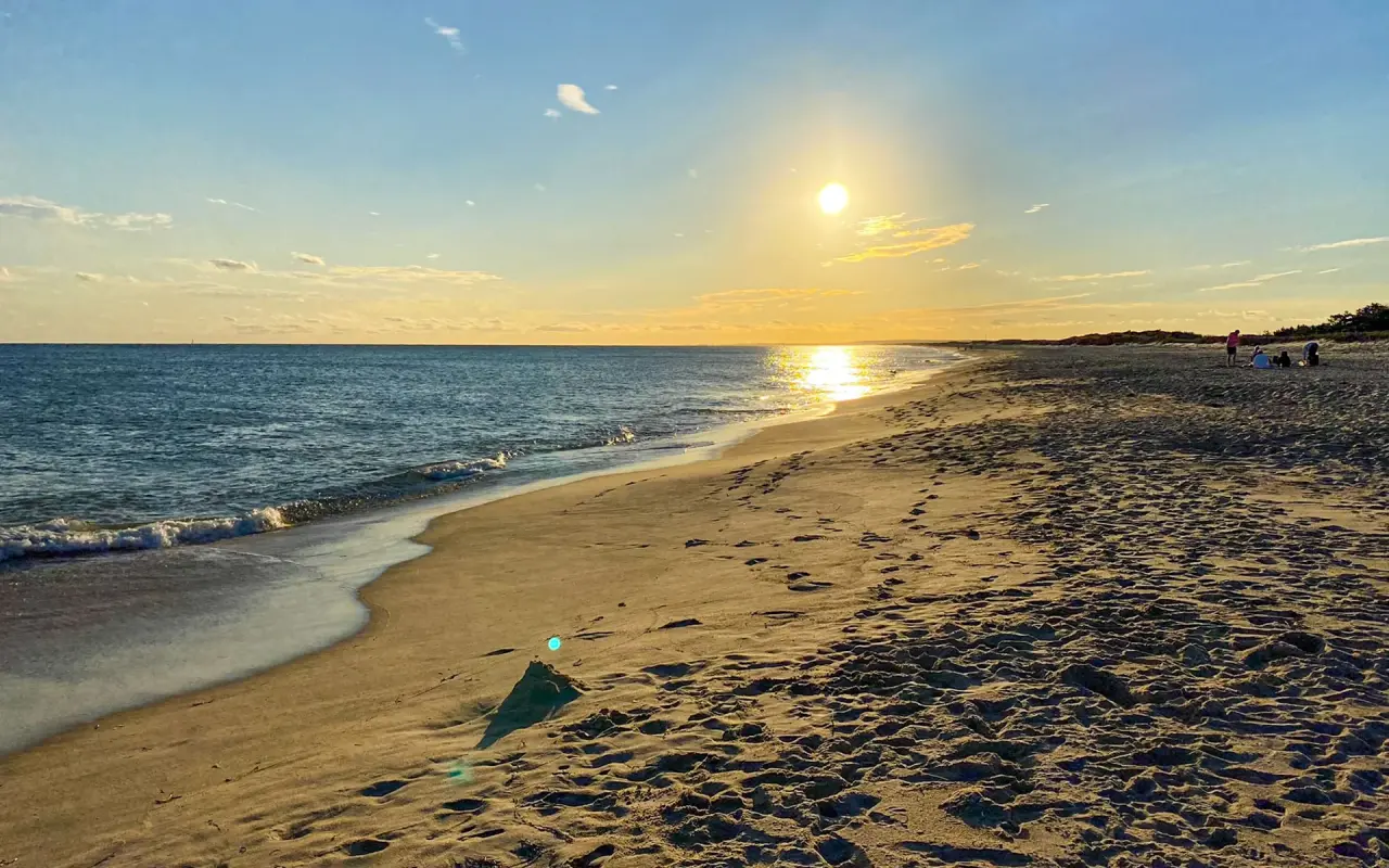 Low sun over the wet sand and surf at South Beach in Katama