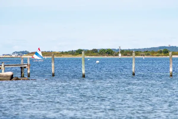 Old pilings and a small sailboat off a Vineyard Haven beach