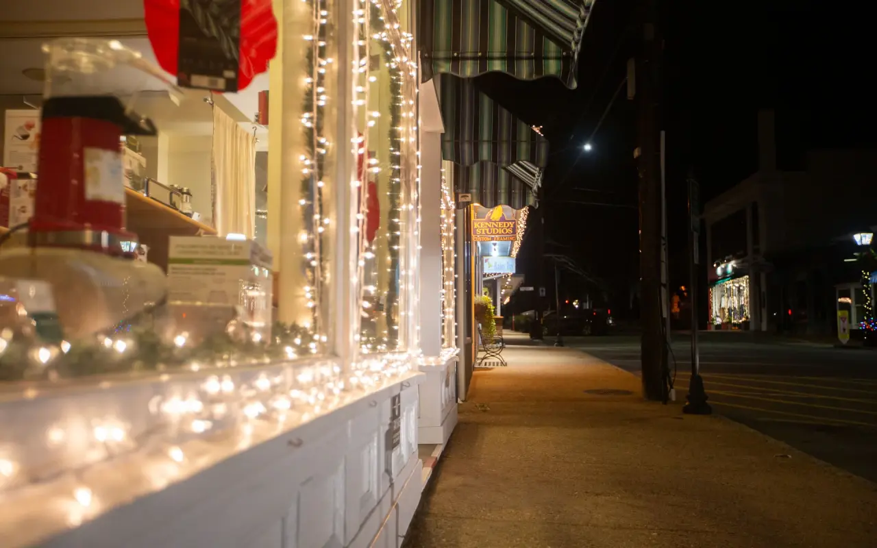 Main Street in Vineyard Haven at night with lit shop windows and string lights