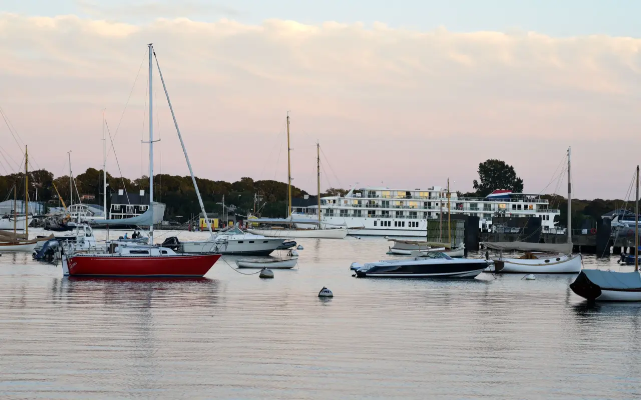 Sailboats and small boats moored in Vineyard Haven Harbor at dusk