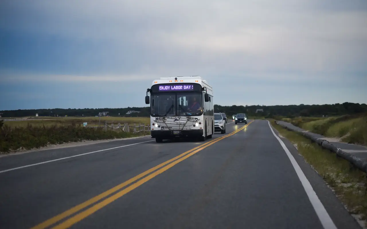 A Vineyard Transit Authority bus on Beach Road with an Enjoy Labor Day sign