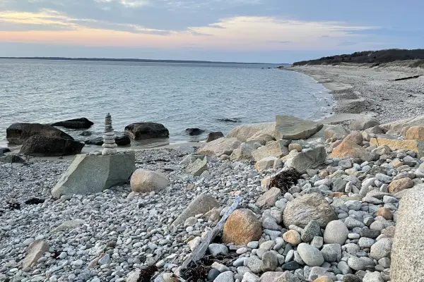 Cobblestones and a stone cairn at dusk on a West Tisbury beach