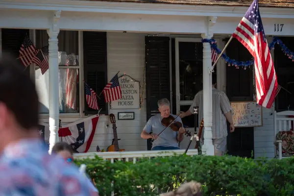 A fiddler playing live music on the porch of the Alison Boylston Piazza House on the Fourth of July, Edgartown