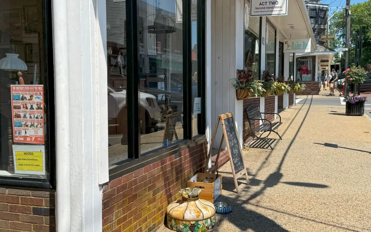 Storefront of Act Two Second Hand Store on Main Street in Vineyard Haven with a stained-glass lamp and a chalkboard sign on the sidewalk