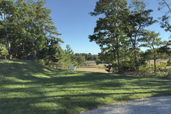 A white Adirondack chair looking over a meadow in Oak Bluffs