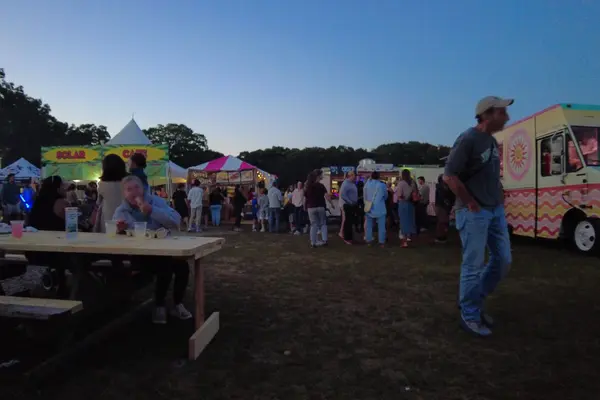Food trucks and picnic tables at the fair, dusk