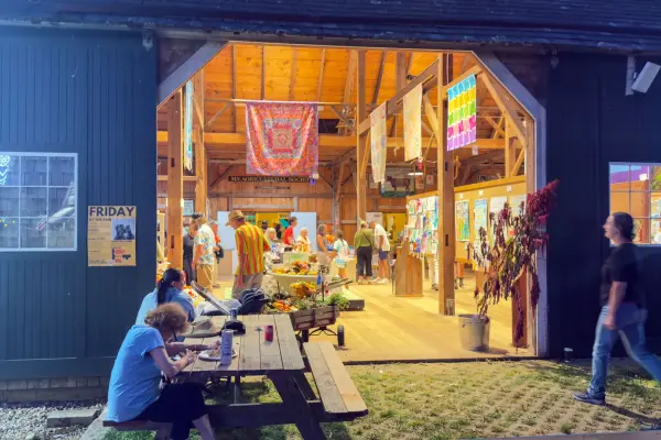 The Agricultural Hall keeps its doors open into the evening, exhibits glowing inside