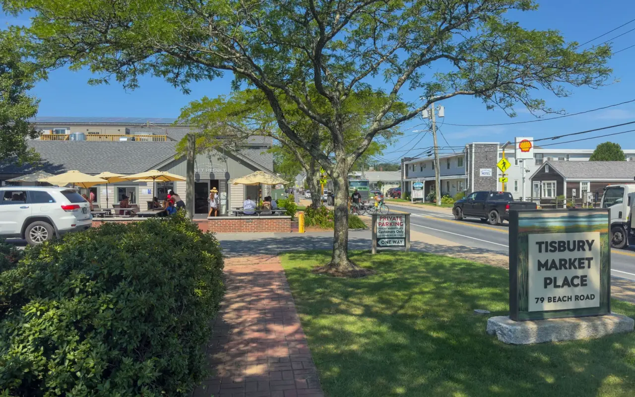 The Tisbury Market Place sign and shops under trees on Beach Road in Vineyard Haven