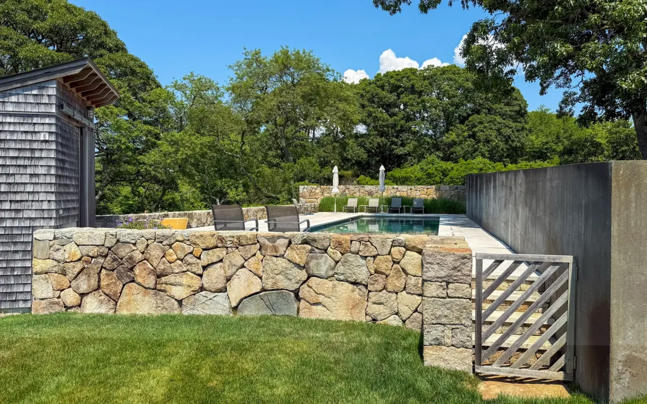 Martha's Vineyard vacation home with cedar shingles, a fieldstone wall and a pool