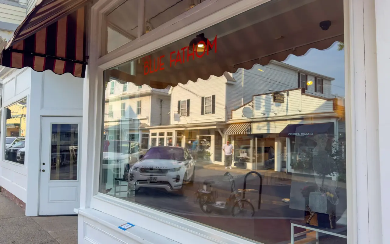 Shop window of the Blue Fathom gallery on Main Street in Vineyard Haven with a striped awning