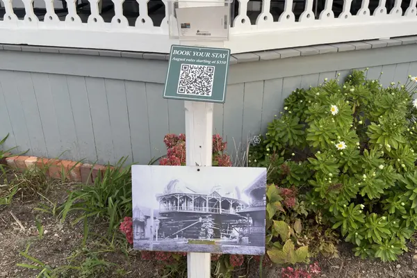 A Book Your Stay sign and an old photo of a cottage on cribbing, Oak Bluffs