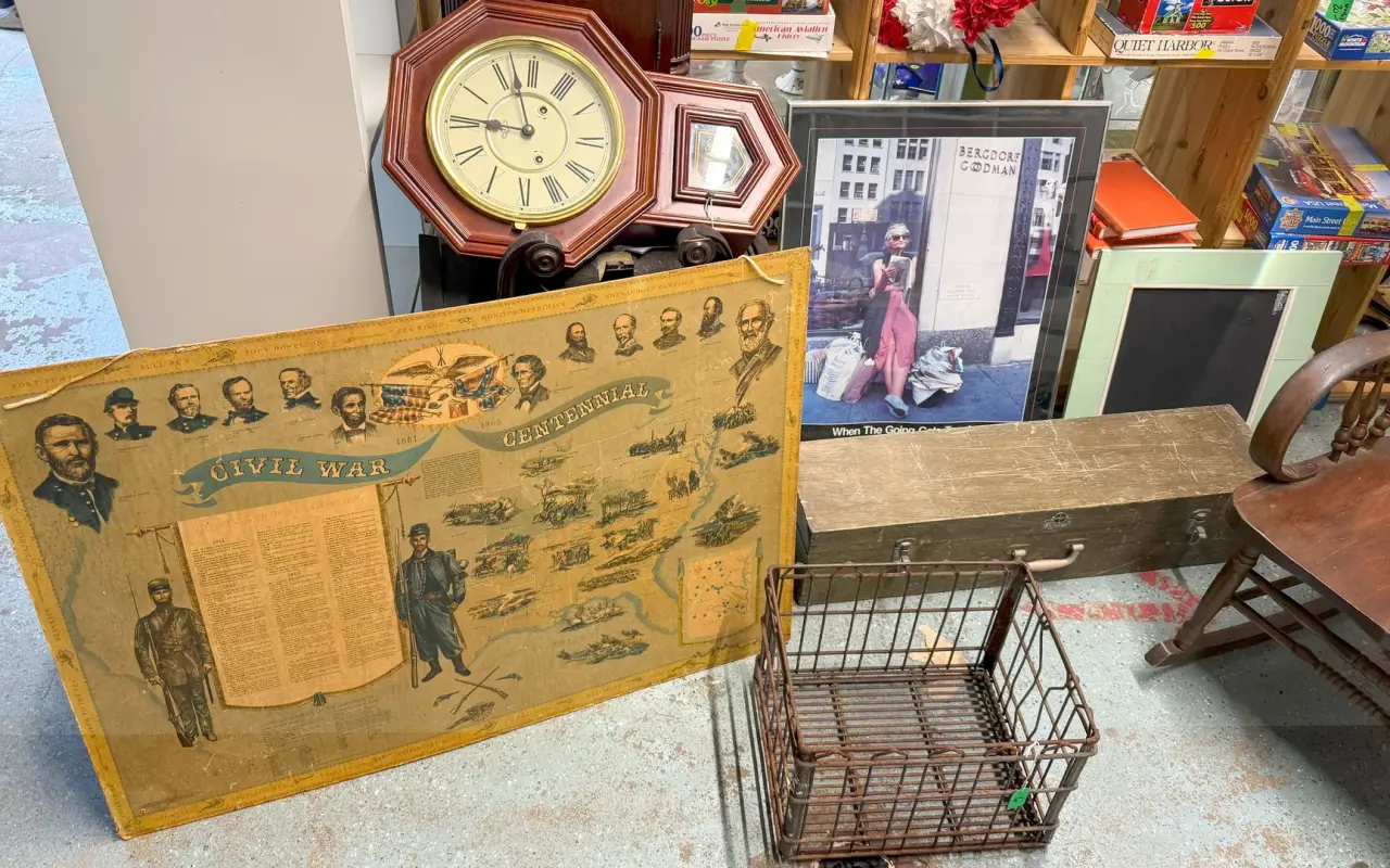 A cluttered display of thrift-shop finds including a wall clock, a wire basket and a vintage island map at Chicken Alley in Vineyard Haven