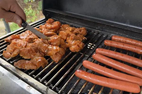 Chicken and hot dogs on a backyard grill in October