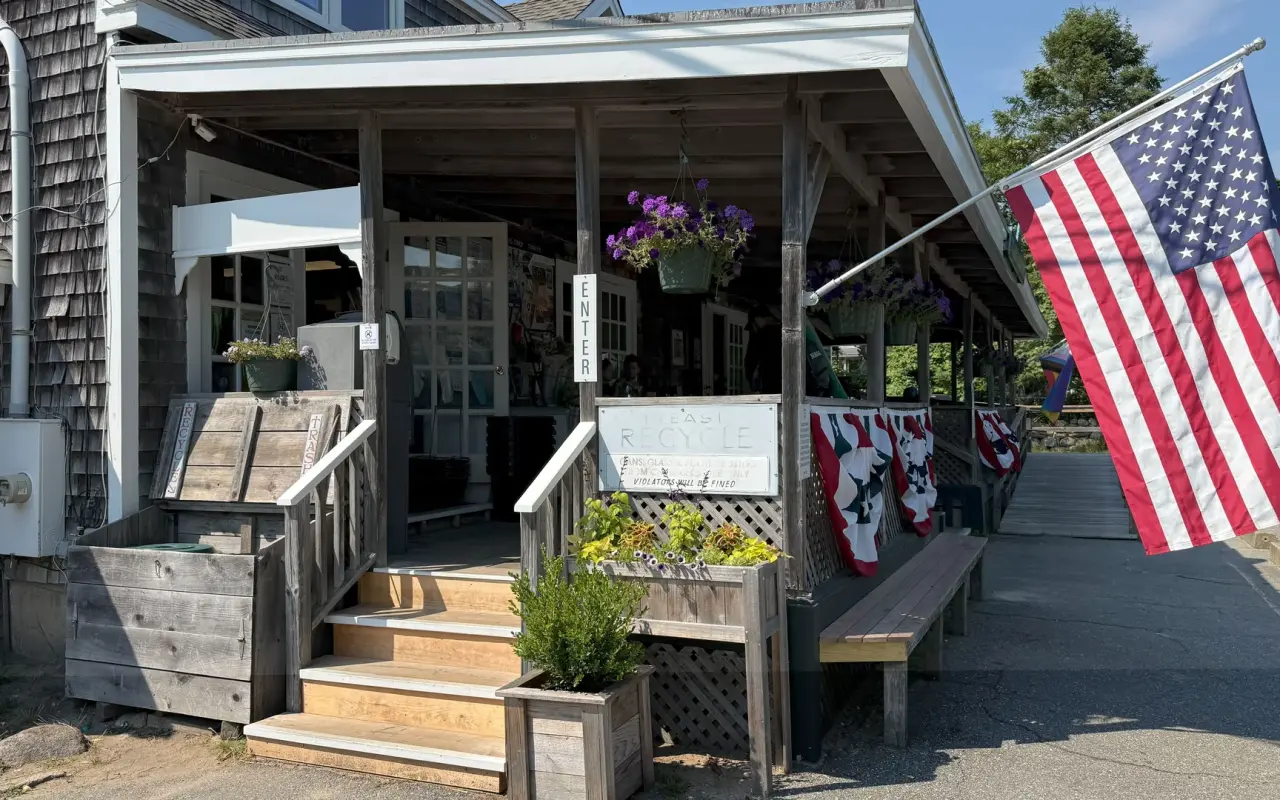 The porch of the Chilmark General Store with flags and flower baskets