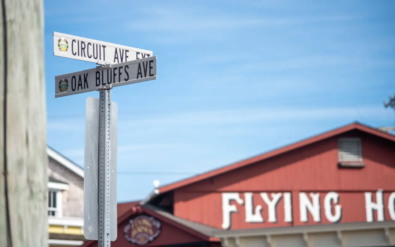 Street signs for Circuit Ave and Oak Bluffs Ave in front of the red Flying Horses carousel building