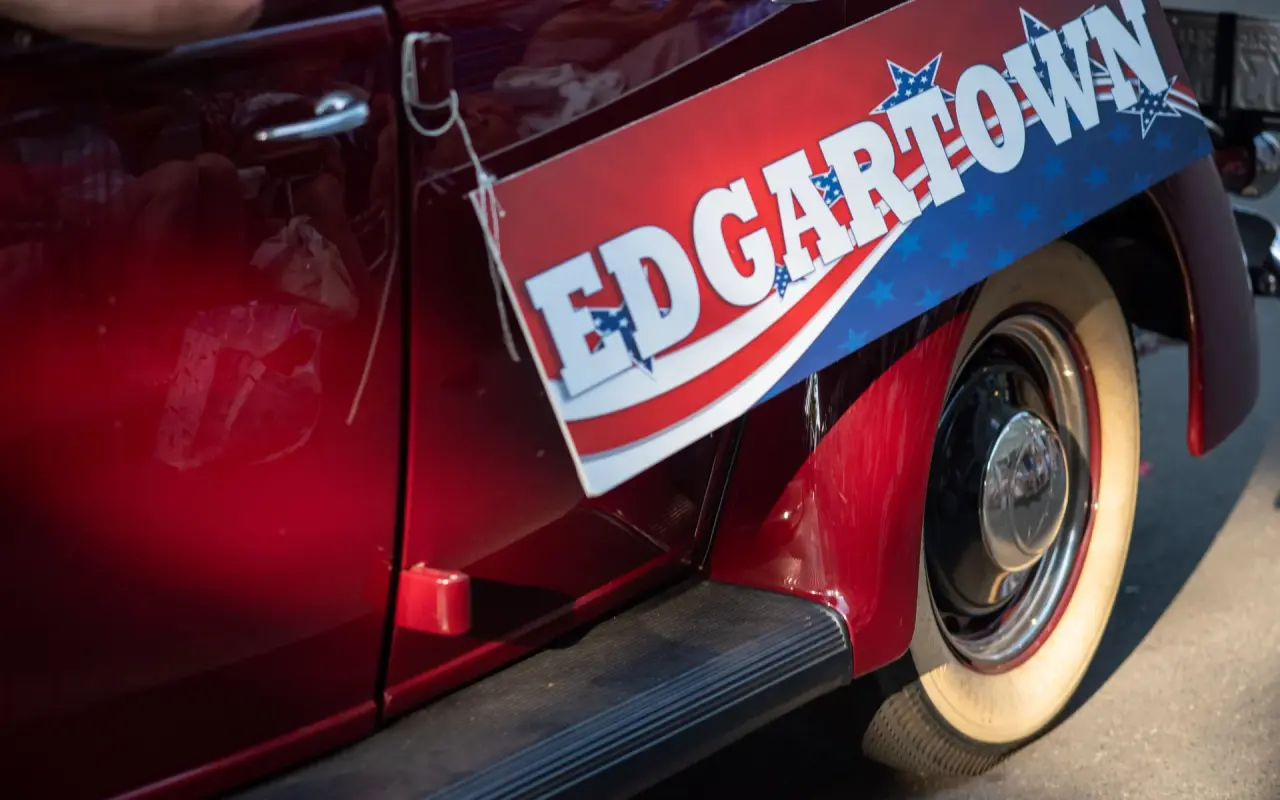 Close-up of a red vintage car with whitewall tires and an Edgartown banner