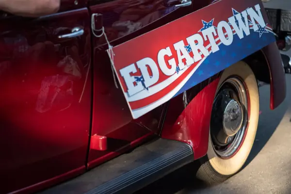 A vintage car with an "Edgartown" placard in the Fourth of July parade